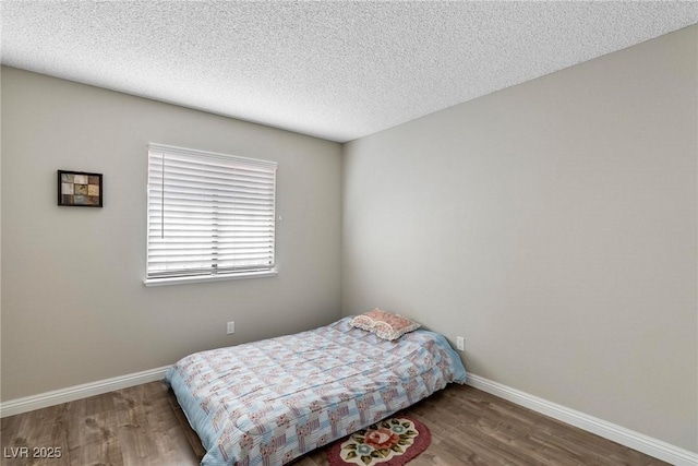 bedroom with wood-type flooring and a textured ceiling