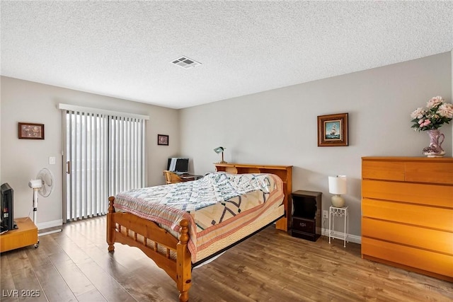 bedroom with hardwood / wood-style floors and a textured ceiling