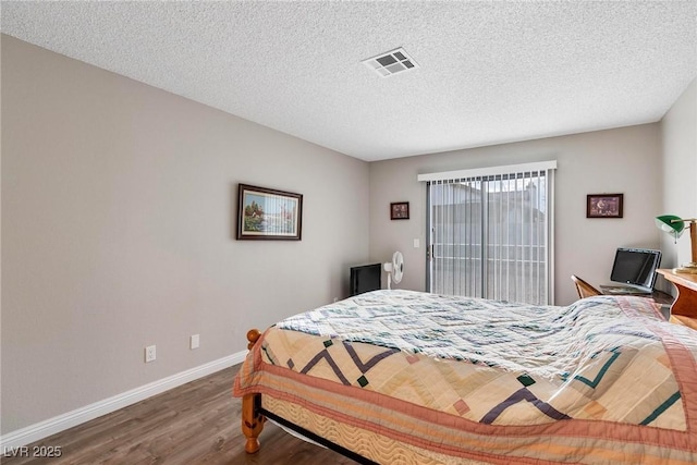 bedroom with hardwood / wood-style floors and a textured ceiling