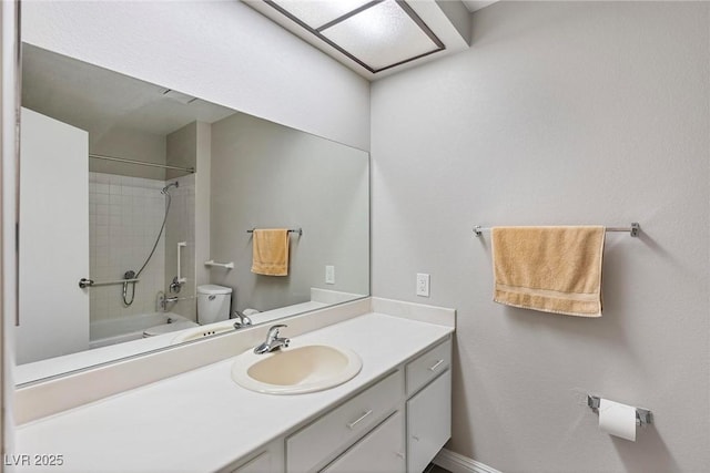 full bathroom featuring vanity, tiled shower / bath combo, and toilet