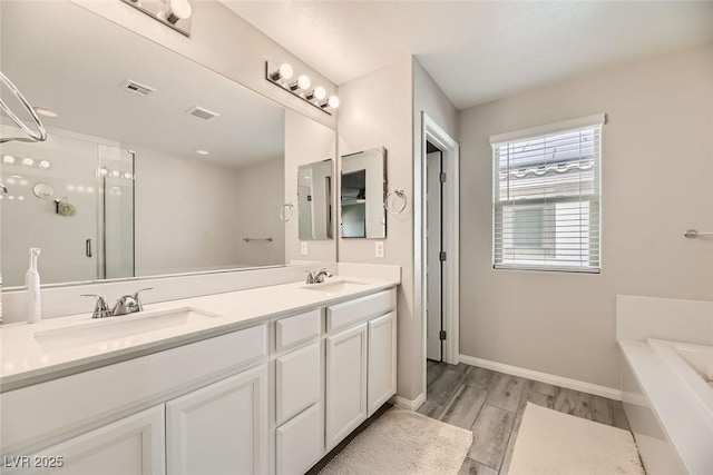 bathroom featuring hardwood / wood-style flooring, vanity, and a washtub