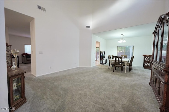 dining area featuring light colored carpet and a notable chandelier