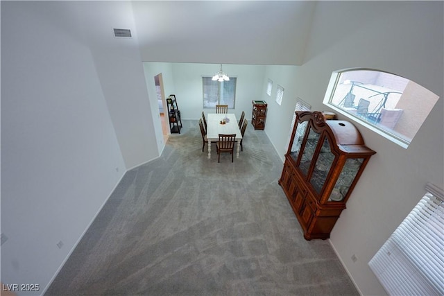 dining room with carpet floors and an inviting chandelier