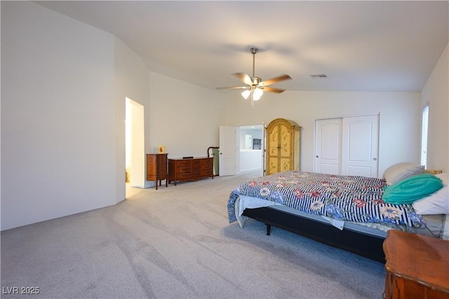 carpeted bedroom with ceiling fan, a closet, and vaulted ceiling