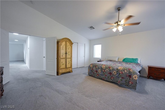 bedroom featuring ceiling fan, a closet, light carpet, and vaulted ceiling