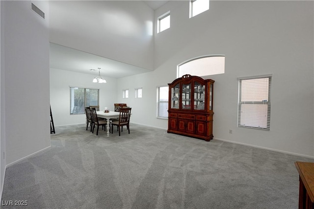 dining space with a high ceiling, light colored carpet, and a healthy amount of sunlight