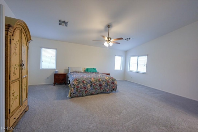 bedroom featuring dark carpet, multiple windows, vaulted ceiling, and ceiling fan