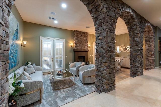 living room with ornate columns and a fireplace