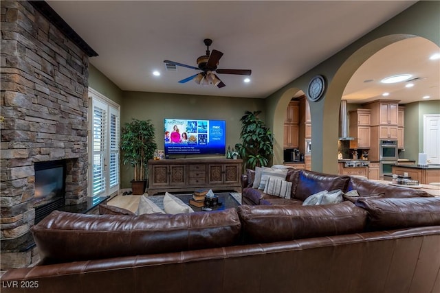 living room featuring ceiling fan and a fireplace