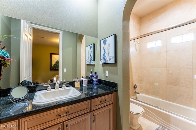 full bathroom with tile patterned floors, vanity, a textured ceiling, toilet, and tiled shower / bath