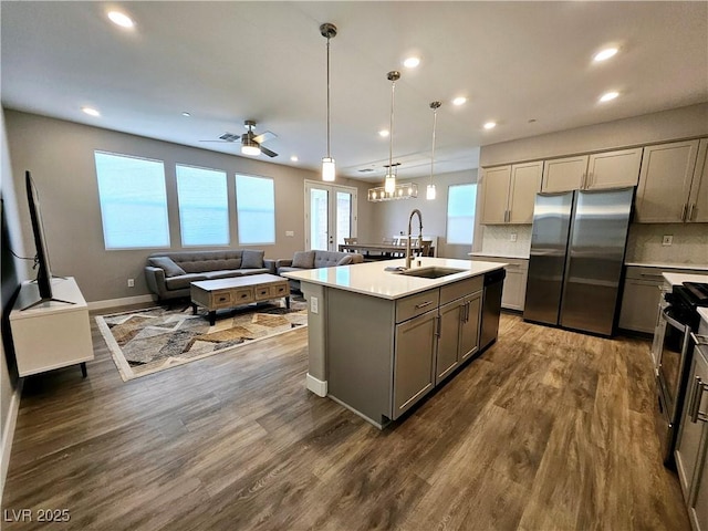 kitchen featuring a center island with sink, sink, ceiling fan, gray cabinets, and appliances with stainless steel finishes