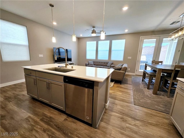 kitchen with ceiling fan, dishwasher, decorative light fixtures, gray cabinets, and a kitchen island with sink