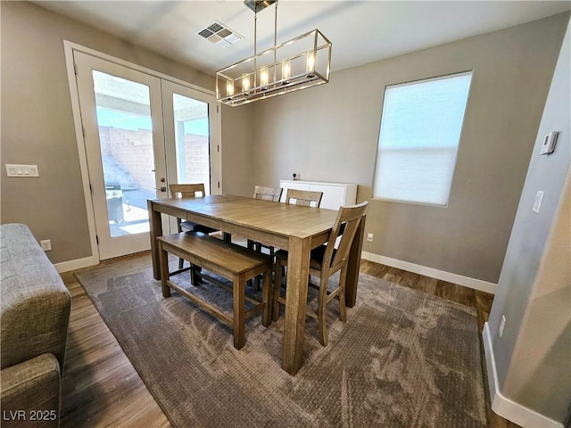 dining space with dark hardwood / wood-style floors and french doors