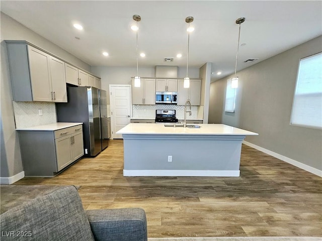 kitchen featuring gray cabinetry, decorative light fixtures, and appliances with stainless steel finishes