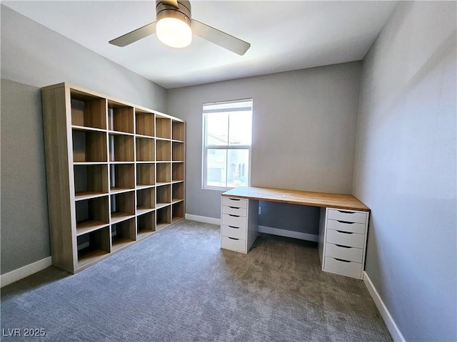 unfurnished office featuring dark colored carpet and ceiling fan