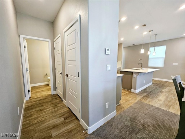 hallway with hardwood / wood-style flooring and sink