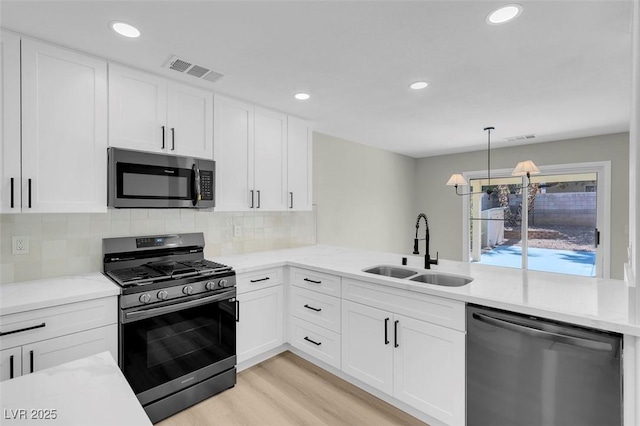 kitchen featuring appliances with stainless steel finishes, white cabinetry, and sink