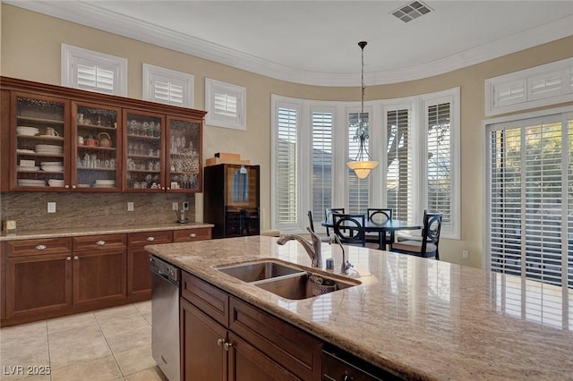 kitchen with sink, stainless steel dishwasher, light stone countertops, light tile patterned floors, and decorative light fixtures