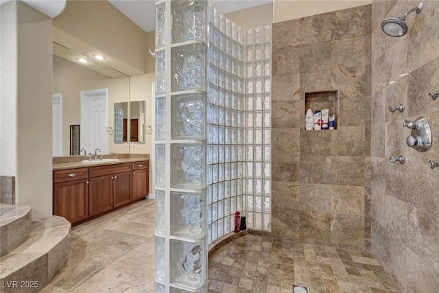 bathroom with vanity and tiled shower