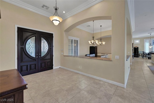 foyer featuring a notable chandelier, light tile patterned flooring, ornamental molding, and french doors