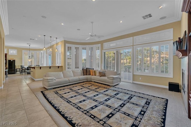 tiled living room featuring ornamental molding, ceiling fan, and a healthy amount of sunlight