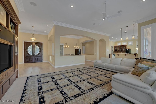 living room featuring ceiling fan with notable chandelier, light tile patterned floors, and ornamental molding