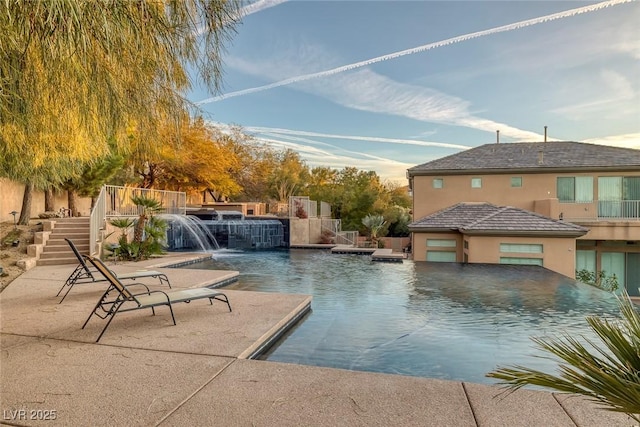 view of pool with pool water feature and a patio