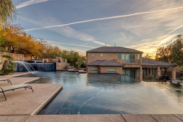 pool at dusk with pool water feature