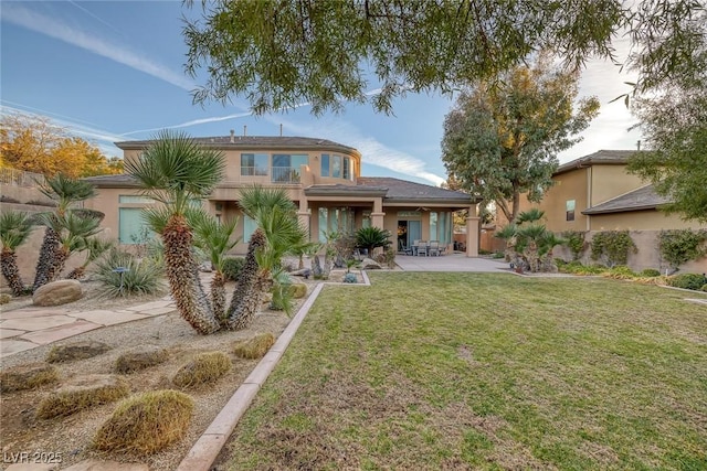 back of house featuring a lawn and a patio