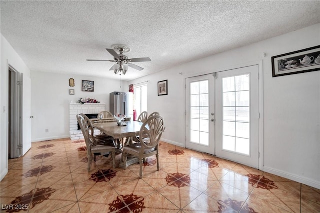 dining area featuring ceiling fan, light tile patterned flooring, a textured ceiling, and french doors