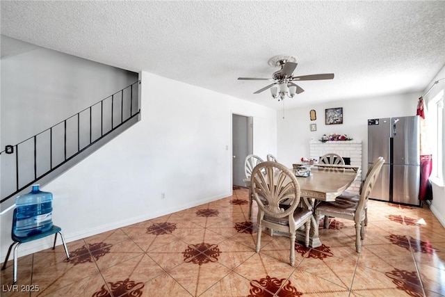 dining room with ceiling fan, light tile patterned floors, and a textured ceiling