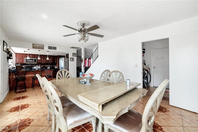 dining space with ceiling fan, light tile patterned floors, and a textured ceiling