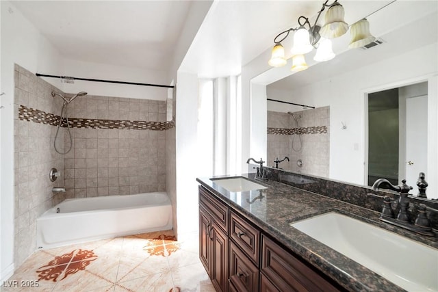 bathroom with tile patterned floors, vanity, and tiled shower / bath