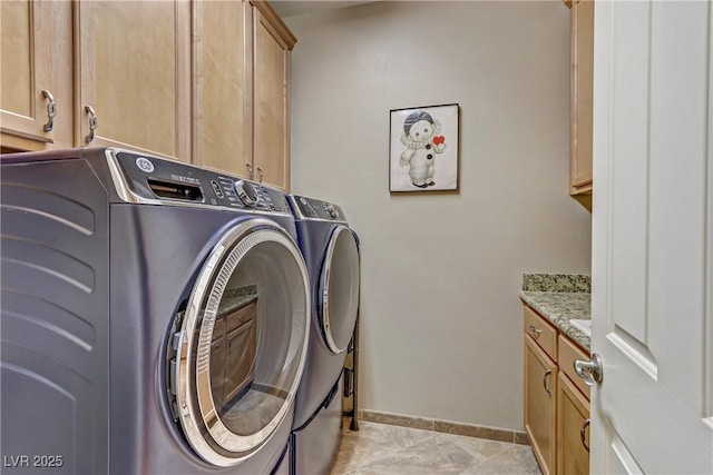 washroom with cabinets, light tile patterned floors, and washer and dryer