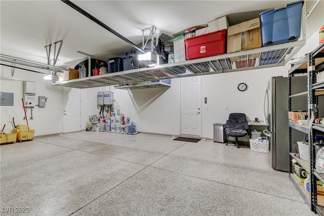 garage featuring electric panel, stainless steel refrigerator, and a garage door opener