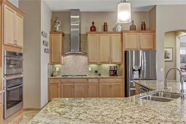 kitchen featuring backsplash, sink, hanging light fixtures, wall chimney exhaust hood, and stainless steel appliances