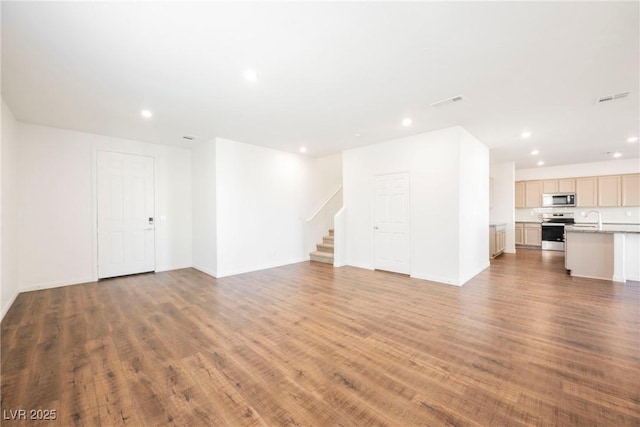 unfurnished living room with hardwood / wood-style flooring and sink