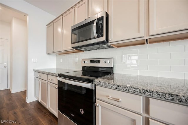 kitchen with backsplash, light stone counters, stainless steel appliances, and dark hardwood / wood-style floors