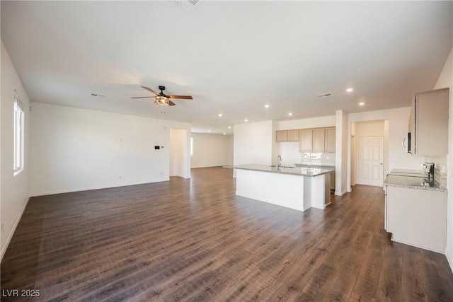 unfurnished living room with ceiling fan, dark wood-type flooring, and sink