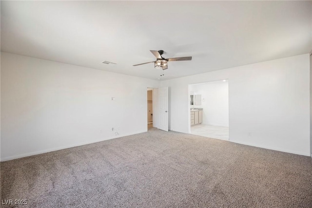 carpeted spare room featuring ceiling fan