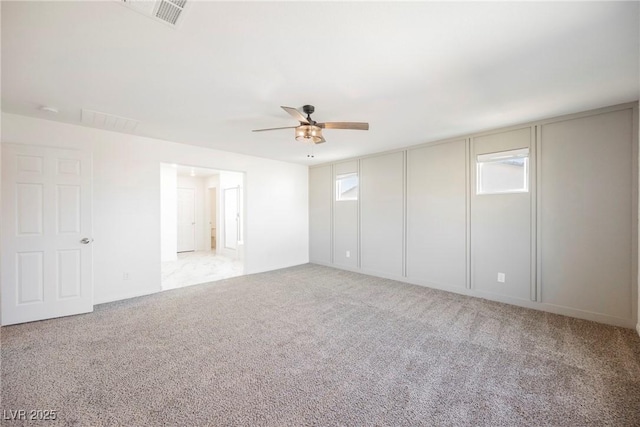 empty room featuring ceiling fan and light colored carpet