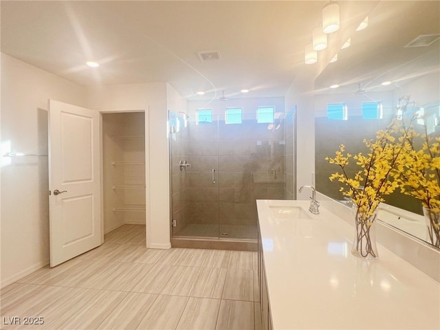 bathroom featuring vanity, a shower with door, and ceiling fan