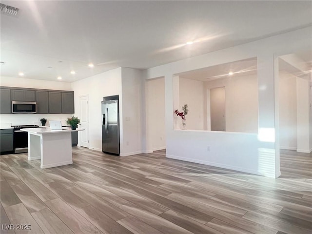 kitchen with a center island, light wood-type flooring, and appliances with stainless steel finishes