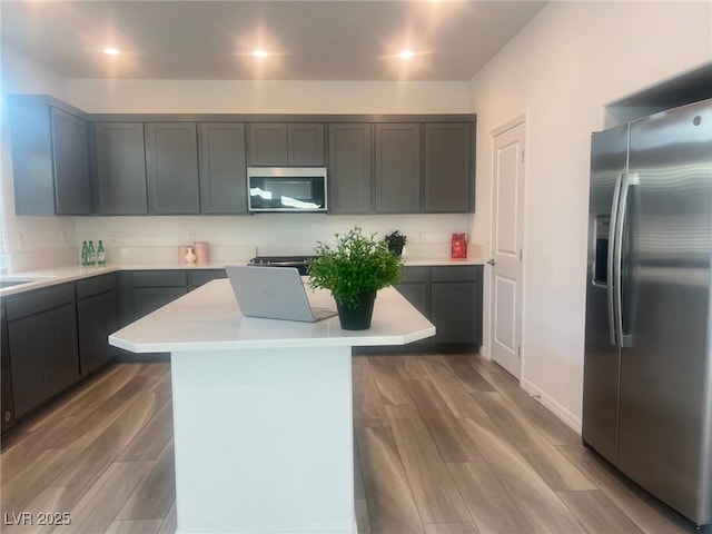 kitchen with wood-type flooring, a center island, and stainless steel appliances