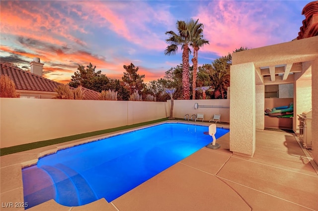 pool at dusk with a patio