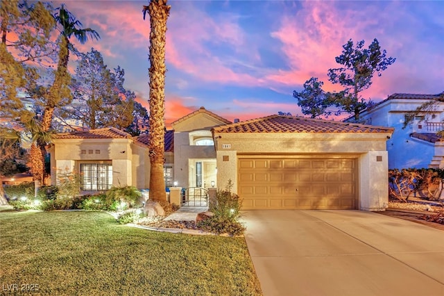 mediterranean / spanish house featuring a yard and a garage