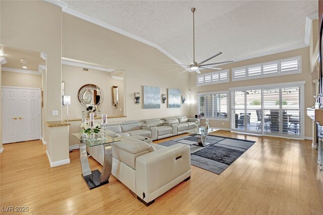 living room with lofted ceiling, ornamental molding, ceiling fan, a textured ceiling, and light wood-type flooring