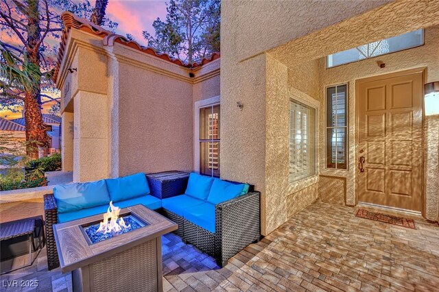 patio terrace at dusk featuring a fire pit