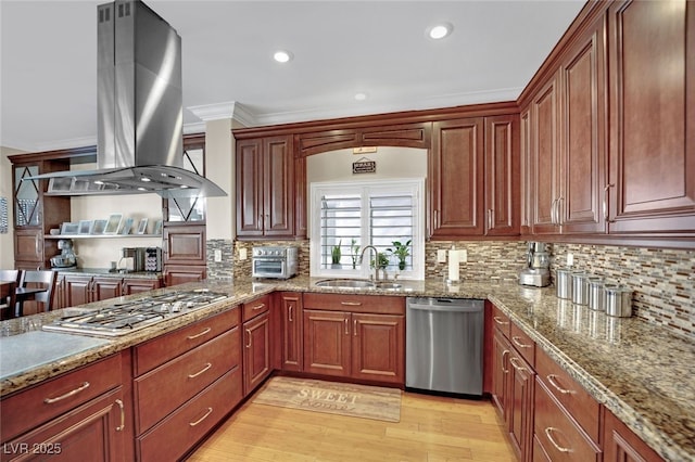 kitchen with sink, crown molding, island exhaust hood, stainless steel appliances, and light hardwood / wood-style floors