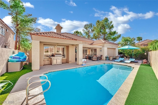 view of swimming pool featuring a grill, a patio, and an outdoor kitchen